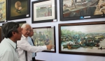 Họa sĩ Trần Khánh Chương, Chủ tịch hội Mỹ thuật Việt Nam (đứng giữa) thuyết trình về các tác phẩm tham gia triển lãm với đại biểu.