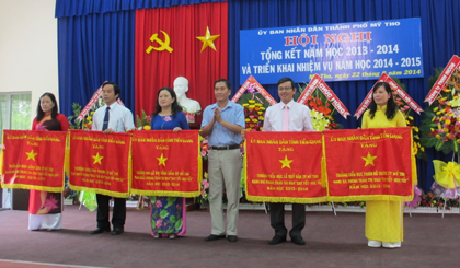 Ông Nguyễn Văn Vững, Phó Chủ tịch UBND TP. Mỹ Tho, trao cờ thi đua cho 5 đơn vị có thành tích cao nhất năm học 2013- 2014.