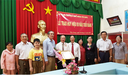 Đồng chí Nguyễn Văn Tấn vinh dự nhận Huy hiệu 50 năm tuổi Đảng, chụp ảnh lưu niệm với đồng chí, bạn bè và gia đình.