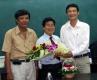 Hiệu Trưởng trường THPT Chuyên Tiền Giang Đặng Vũ Thanh (bên phải) tặng hoa chúc mừng nghiên cứu sinh Võ Phúc Châu