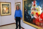 Họa sĩ Kông Tâm bên tác phẩm của mình tại triển lãm