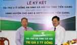 Ông Ngô Minh Nhựt, Giám đốc Vietcombank Tiền Giang (bên phải) trao gói tài trợ ASXH cho Ông Lê Văn Mỹ, Chủ tịch UBND huyện Chợ Gạo.
