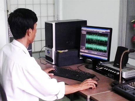 Kỹ thuật viên đài huyện đang xử lý một chương trình phát thanh.