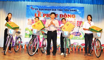 Ông Trần Vĩnh Hưng, Giám đốc Sở LĐ-TB&XH trao xe đạp và quà cho học sinh vượt khó của huyện Cái Bè.