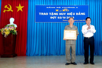 Bí thư Tỉnh ủy Trần Thế Ngọc trao Huy hiệu 65 năm tuổi Đảng cho ông Huỳnh Văn Niềm.