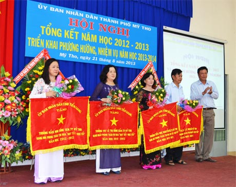 Ông Nguyễn Trọng Hữu, Trưởng Ban Tuyên giáo Thành ủy Mỹ Tho trao cờ và tặng hoa cho 4 đơn vị đạt thành tích xuất sắc trong năm học 2012-2013.