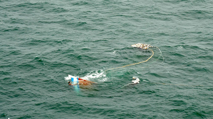 Trực thăng tìm thấy mũi tàu cá nhô lên mặt nước - Ảnh: Xuân Cường