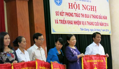 Ông Nguyễn Văn Hoàng, Phó Giám đốc BHXH TP. Mỹ Tho nhận Cờ thi đua , do Phó Tồng Giám đốc BHXH Việt Nam Đỗ Thị Xuân Phương trao.