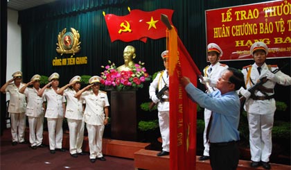 Ông Nguyễn Văn Khang, Phó Bí thư Tỉnh ủy, Chủ tịch UBND tỉnh thực hiện nghi thức trao Huân chương Bảo vệ Tổ quốc hạng Ba của Chủ tịch nước tặng Công an TX. Gò Công.