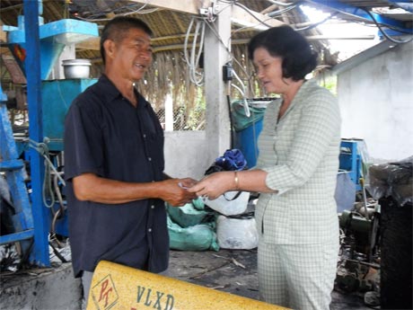 Bà Huỳnh Thị Tỏ, Phó Chủ tịch UBND huyện trao tiền hỗ trợ cho cơ sở nhựa Gia Đức bị cháy. 