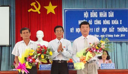 Ông Đặng Văn Châu, Chủ tịch HĐND huyện tặng hoa ông Phạm Văn Bé (bên trái) và ông Lê Hoàng Việt (bên phải).