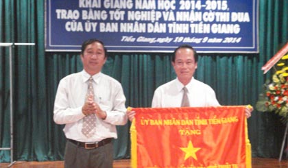 Ông Nguyễn Ngọc Minh, Giám đốc Sở VH-TT&DL trao Cờ thi đua của UBND tỉnh cho trường.