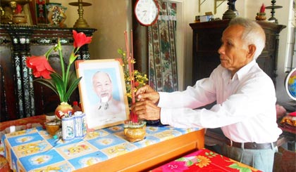  Ông Nguyễn Thanh Bình, cựu chiến binh ấp Mỹ Lợi A, xã Long Tiên bên bàn thờ Bác Hồ.