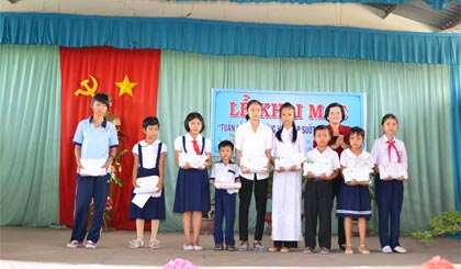 Bà Trần Thị Quý Mão, Phó Giám đốc Sở Giáo dục và Đào tạo trao học bổng và quà cho các học sinh vượt khó học giỏi huyện Chợ Gạo.