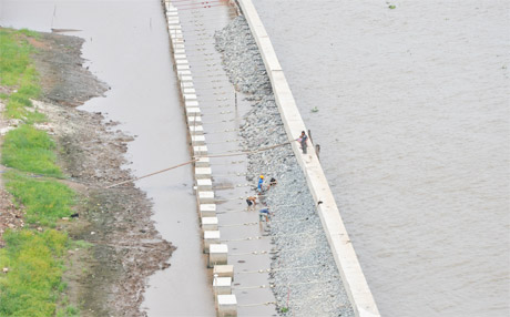 Công nhân đang thi công Dự án đường và bờ kè sông Tiền vào tháng 7-2013. Ảnh: Vân Anh