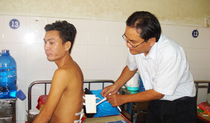 Bác sĩ Nguyễn Quốc Việt kiểm tra vết mổ cho bệnh nhân Nguyễn Văn Lữ sau phẫu thuật thoát vị đĩa đệm tại Khoa Ngoại thần kinh, Bệnh viện Đa khoa tỉnh.