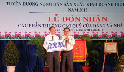 Ông Phan Văn Hà, Chủ tịch Hội Bảo trợ bệnh nhân nghèo, người khuyết tật và trẻ mồ côi tỉnh nhận tượng trưng số tiền hỗ trợ từ HND tỉnh.