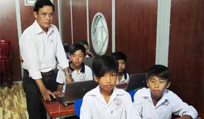 Thầy Lê Hoàng Tuấn đang hướng dẫn các em học sinh thực hành môn Tin học.