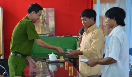 Thượng tá Lê Hoàng Tiến, Trưởng Công an huyện Cái Bè thăm hỏi và trao thưởng cho 2 anh Nguyễn Thanh Nhựt và Huỳnh Minh Trung.