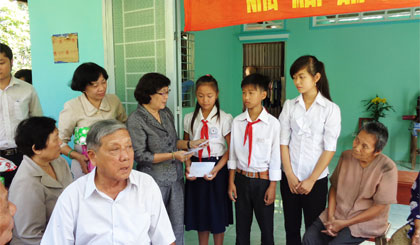 Bà Đồng Thị Bạch Tuyết, Chủ tịch Hội Khuyến học tỉnh trao quà cho 3 chị em Hân, Khanh và Duyên trong buổi bàn giao “Mái ấm khuyến học” cho 3 em.