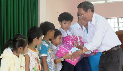 Ông Phan Văn Hà - Chủ tịch Hội Bảo trợ bệnh nhân nghèo, người khuyết tật và trẻ mồ côi tỉnh Tiền Giang tặng quà cho các em.