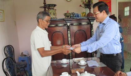 Đồng chí Lê Hồng Quang tặng phần tiền mặt cho ông Nguyễn Văn Lắm, cư ngụ tại phường 3, thị xã Gò Công.