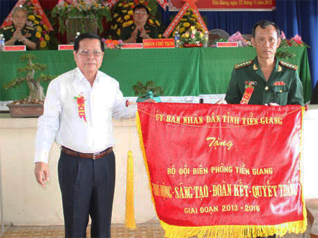 Chủ tịch UBND tỉnh Nguyễn Văn Khang trao Cờ thi đua cho lãnh đạo Bộ Chỉ huy BĐBP Tiền Giang. Ảnh: 