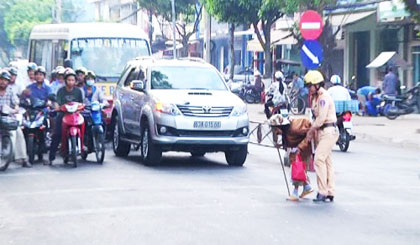 Một cụ già được nữ Cảnh sát giao thông dẫn qua đường.