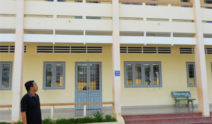 Anh Nguyễn Văn Hiền bên ngôi trường mới do anh hiến đất xây dựng.