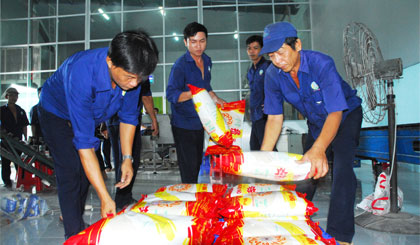 Công nhân Xí nghiệp chế biến gạo chất lượng cao đang đóng gói gạo “Chín con Rồng Vàng”.