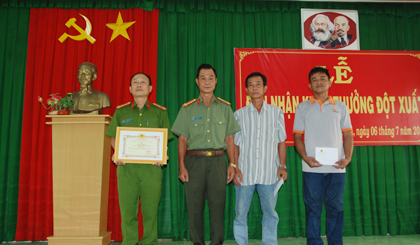 Đại tá Nguyễn Văn Lộc, Phó Giám đốc Công an tỉnh trao thưởng 2 anh Nguyễn Sơn Khanh và anh Trịnh Văn Thương. Ảnh: HOÀN THANH