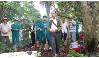 Ông Nguyễn Bền (đứng trước), Chủ tịch Hội CCB huyện Châu Thành, tham gia cải táng hài cốt liệt sĩ.