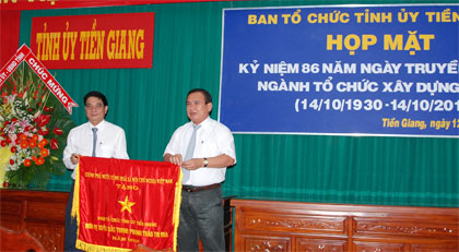 Được sự ủy nhiệm, Phó Bí thư Tỉnh ủy Võ Văn Bình (bên phải) trao Cờ thi đua của Thủ tướng Chính phủ cho Ban Tổ chức Tỉnh ủy.