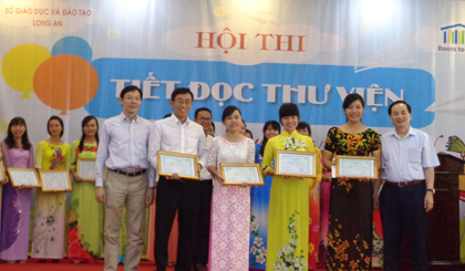 Ông Phạm Ngọc Định, Vụ trưởng Vụ Giáo dục tiểu học (Bộ GD-ĐT) và ông Lê Tiên Phong, Giám đốc Room to Read tại Việt Nam trao giải Nhất “Hội thi TĐTV năm 2016” cho các thí sinh.