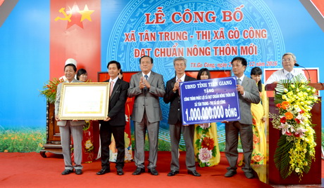 Ông Lê Văn Nghĩa, Phó Chủ tịch UBND tỉnh trao bằng công nhận “Xã đạt chuẩn nông thôn mới” và công trình phúc lợi trị giá 1 tỷ đồng cho xã Tân Trung.