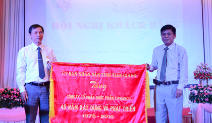 Ông Phạm Quang Bình (trái) nhận Cờ của UBND tỉnh.