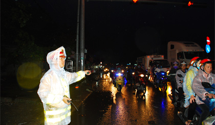 Cảnh sát giao thông dầm mưa điều tiết giao thông ở ngã tư Đồng Tâm.