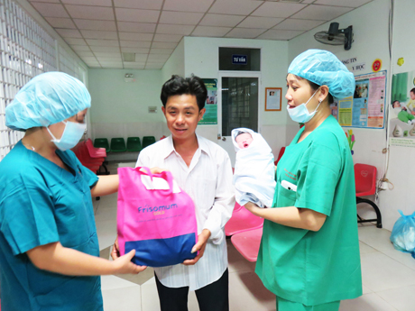 Đại diện Bệnh viện Phụ sản Tiền Giang tặng quà cho thân nhân em bé được sinh ra đầu tiên của năm Đinh Dậu 2017 tại Tiền Giang.