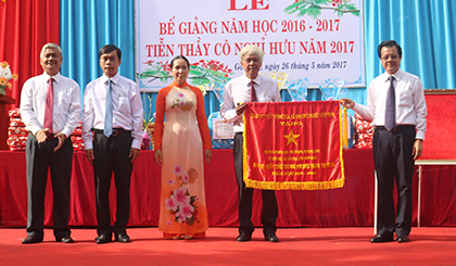 Ông Lê Hồng Quang, Ủy viên BCH TƯ Đảng, Phó Bí thư Thường trực Tỉnh ủy (bìa phải) trao Cờ thi đua xuất sắc của Chính phủ cho BGH Trường THPT Trương Định.