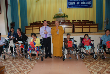 Phó Chủ tịch UBND tỉnh Trần Thanh Đức và Hòa thượng Thích Huệ Minh, Trường Ban Trị sự Phật giáo tỉnh trao xe lăn và quà tặng cho nạn nhân chất độc da cam bị khuyết tật vận động.