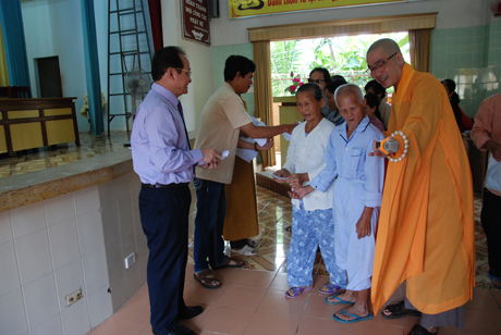Phó Chủ tịch UBND tỉnh Trần Thanh Đức và đại đức Thích Quảng Lộc,Trường Ban Trị sự Phật giáo TP. Mỹ Tho trao quà tặng cho nạn nhân chất độc da cam.