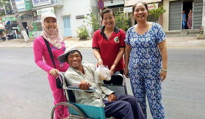 Chị Loan (người đứng giữa) đem trao những phần thức ăn đến tận tay người khuyết tật.