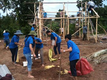 Các bạn cùng thanh niên địa phương phụ giúp dựng lại nhà cho anh Khắc Chương ở xã Phú Đông.