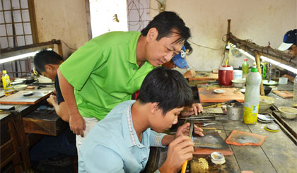 Anh Nguyễn Ngọc Dũng hướng dẫn thợ bạc thực hiện mẫu dây chuyền mới.