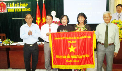 Ông Huỳnh Anh Tuấn, Thường trực Hội đồng Thi đua - khen thưởng tỉnh trao Cờ thi đua của Chính phủ cho lãnh đạo Sở Tư pháp tại hội nghị.