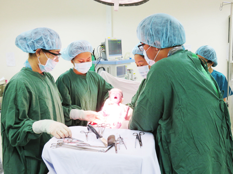 Dưới sự trợ giúp đắc lực của các y - bác sĩ, em bé được sinh ra khỏe mạnh.