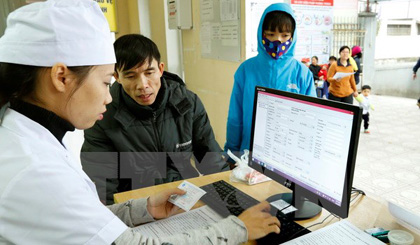 Nhân viên y tế làm thủ tục khám chữa bệnh cho người dân. (Ảnh: TTXVN/Vietnam+)