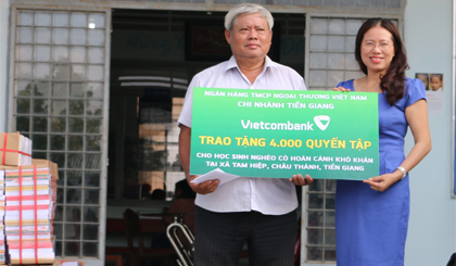 Bà Nguyễn Thị Tuyết, Phó Giám đốc Vietcombank Tiền Giang trao 4.000 quyển tập cho ông Nguyễn Văn Son, Chủ tịch Hội khuyến học xã Tam Hiệp.